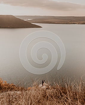 wedding couple in love stand on the Big Stone on the cliff and kiss. panoramic view