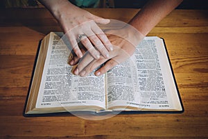 Wedding couple or marriage, praying over the open bible.