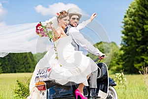 Wedding couple on motor scooter just married photo