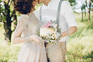 Wedding couple on nature. the bride and groom with cake at wedding.