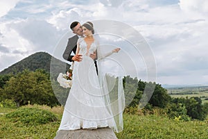 wedding couple on nature. bride and groom hugging under the veil