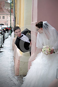 Wedding couple playing hide and seek photo