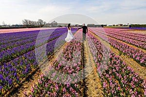 Wedding couple posing in field with flowers