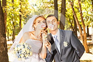 Wedding couple posing with stick lips, mask