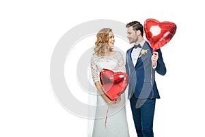 Wedding couple with red heart shaped balloons