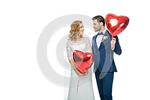 Wedding couple with red heart shaped balloons photo
