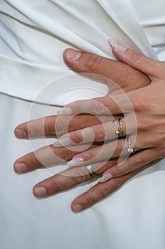 Wedding couple rings fingers bride and groom hands on marriage wed white dress background