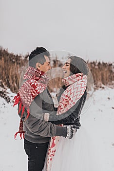 wedding couple running lying in snow laughing having fun playing snowballs