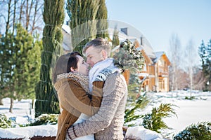 Wedding couple in a showy wither day, holding each other, rustic style short wedding dress. Girl brunette. beautiful bride winter