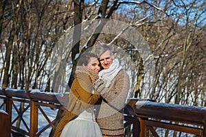 Wedding couple in a showy wither day, holding each other, rustic style short wedding dress. Girl brunette. beautiful bride winter