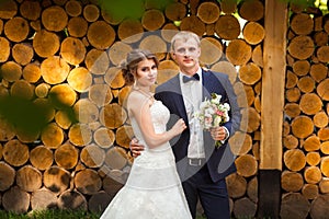 Wedding couple standing in front of logs