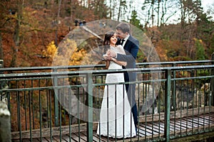 Wedding couple standing in the mountains against the sky. Cute romantic moment. Best day in the life of the bride.