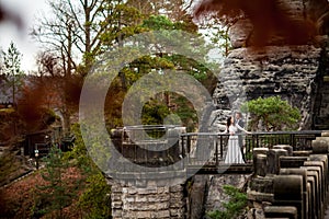 Wedding couple standing in the mountains against the sky. Cute romantic moment. Best day in the life of the bride.