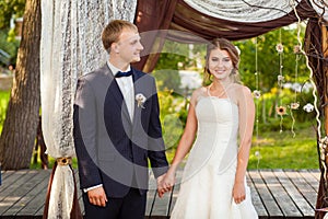 Wedding couple under wedding arch in summer