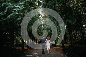 Wedding couple walks in forest