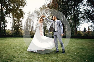 Wedding couple walks in the park and dances, the bride and groom have fun