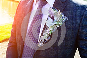 Wedding day. Beautiful creative groom boutonniere on the suit of
