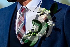 Wedding day. Beautiful creative groom boutonniere on the suit of