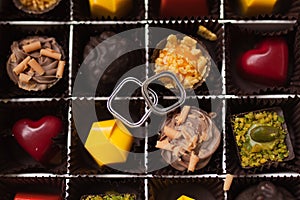 Wedding day. Beautiful rings of the groom and the bride in a box with colored sweets photo