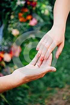 Wedding day. Bride and groom, love concept. Young family. Newlyweds hands. Outdoor wedding ceremony. Married couple. Wedding rings