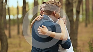 Wedding day. The bride hugs the groom. Loving couple in a pine forest. Looking at each other.