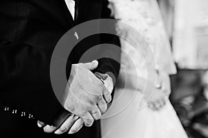 Wedding day. Hands in hands of newlywed couple