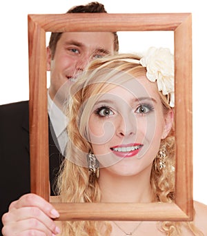 Wedding day. Happy couple in wooden frame isolated