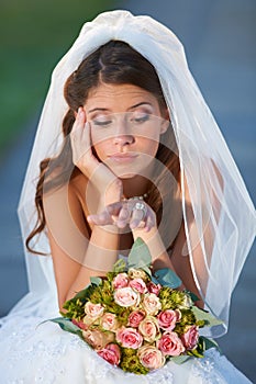 Wedding day jitters. a young bride looking upset while sitting down and holding her bouquet.