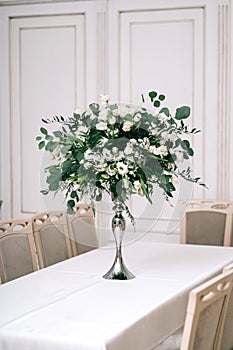 Wedding decor, accessories, orchids, roses, eucalyptus, a bouquet in a restaurant, chairs table setting