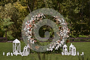 Wedding decor with flowers and candles. This is round arch of foliage and flowers. Outside wedding ceremony