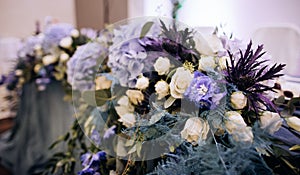 Wedding  decor of fresh blue and white flowers on tables at a wedding party at a restaurant