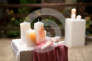 Wedding decor in pink style with crystals, lace, flowers and initials. Wedding candles for the family hearth.