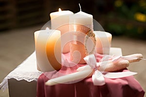 Wedding decor in pink style with crystals, lace, flowers and initials. Wedding candles for the family hearth.