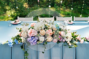 Wedding decor. Table for the newlyweds outdoor. Wedding reception. Elegant wedding table arrangement, floral decoration, restauran