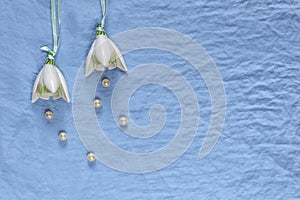 Wedding decor. White ceramic flowers, pearls on a blue fabric ba