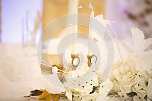 Wedding decor in white and gold style with crystals, lace and flowers. Wedding candles for the family hearth.