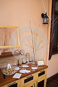 Wedding decoration. Golden walnut in a glass round vase. The wish tree