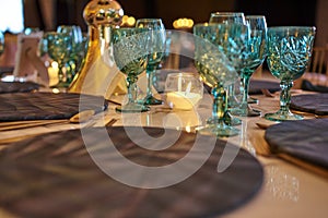 Luxury table flower green decoration with glass globets wedding event party at night, coctel table with candles photo
