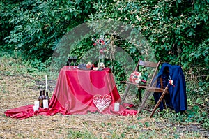 Wedding decorations outdoors. Glasses of wine, plate with fruits and floral decorations on the table.