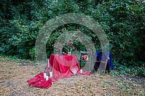 Wedding decorations outdoors. Glasses of wine, plate with fruits and floral decorations on the table.