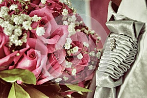 Wedding detail with the bride's beautiful bouquet and her roses, and the groom's elegant outfit with his silver tie