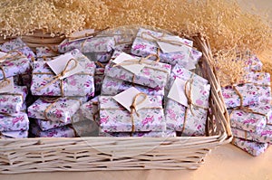 Wedding details favors colorful floral pattern gift boxes with soaps for guests in white wicker basket