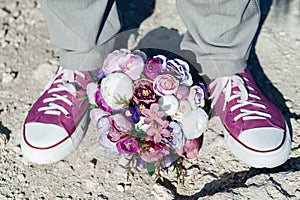 Wedding details in the form of purple sneakers and a purple wedding bouquet.