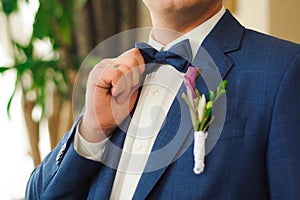 Wedding details. Groom accessories, A man in a jacket with a boutonniere.