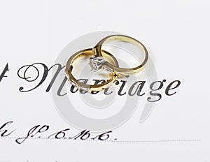 Wedding and diamond engagement rings on marriage certificate