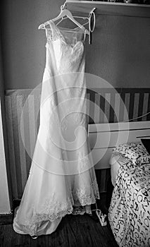 Wedding dress and groom preparing at the window photo