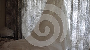 Wedding dress hanging in front of a window