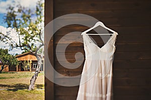 Wedding dress hanging on a wooden wall