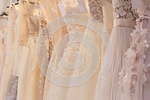 Wedding dresses hang on a hanger in a row