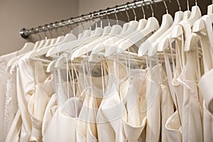 Wedding dresses hanging on a hanger. Fashion look. Interior of bridal salon.